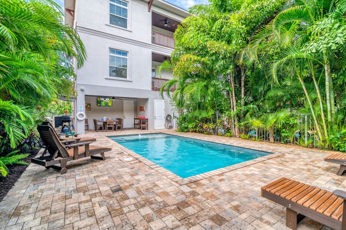 Your private resort moment: sparkling pool, stylish patio, cabana hideaway, and lush palms swaying in the coastal breeze—paradise is yours.