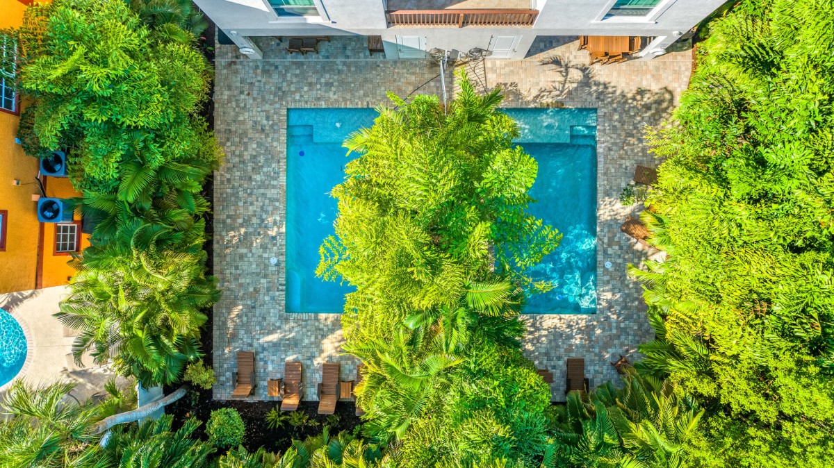 Your private oasis begins here—two sparkling rectangular pools each with a Baja tanning shelf and a soothing fountain at its heart.