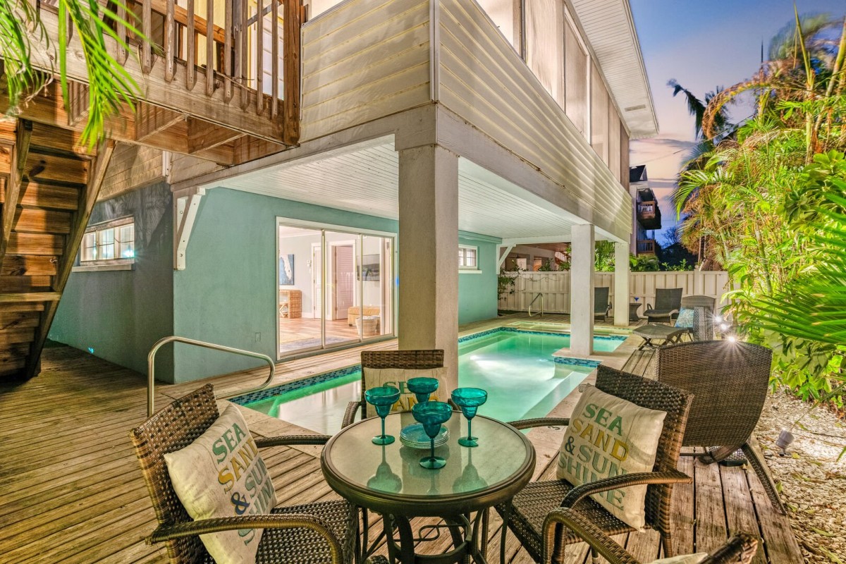Pool with surround deck, tables, seating, and chaise lounges all around the pool area.