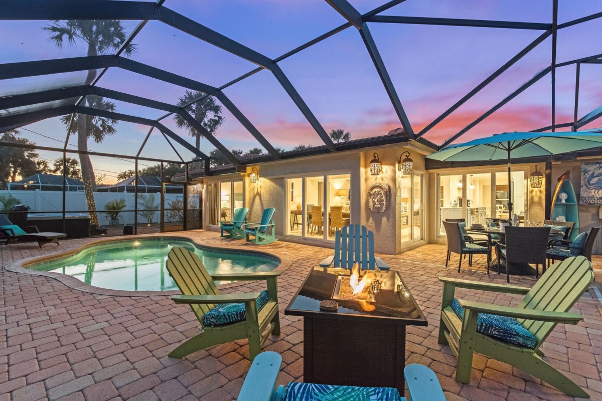 Pool and patio area with screened patio, fire pit and outdoor dining.