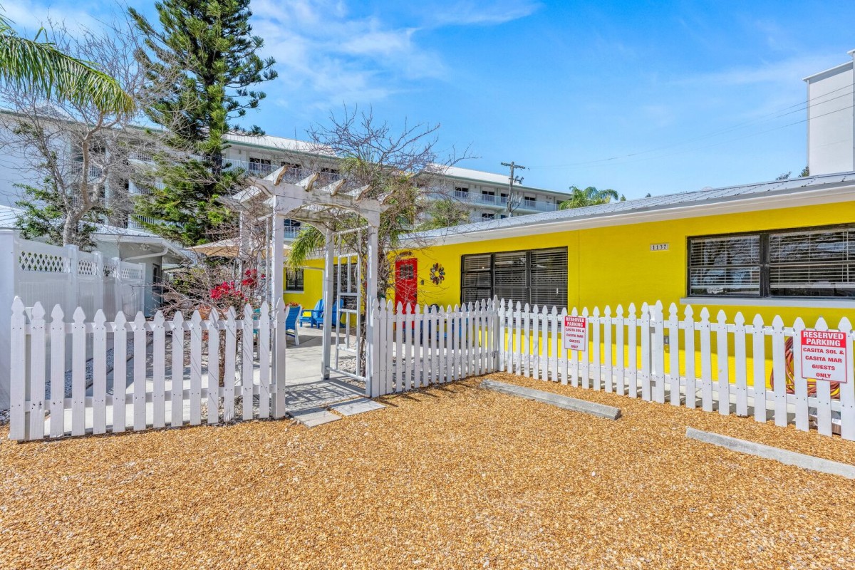 Step onto the cheerful front patio where colorful seating makes morning coffee feel like a vacation ritual.