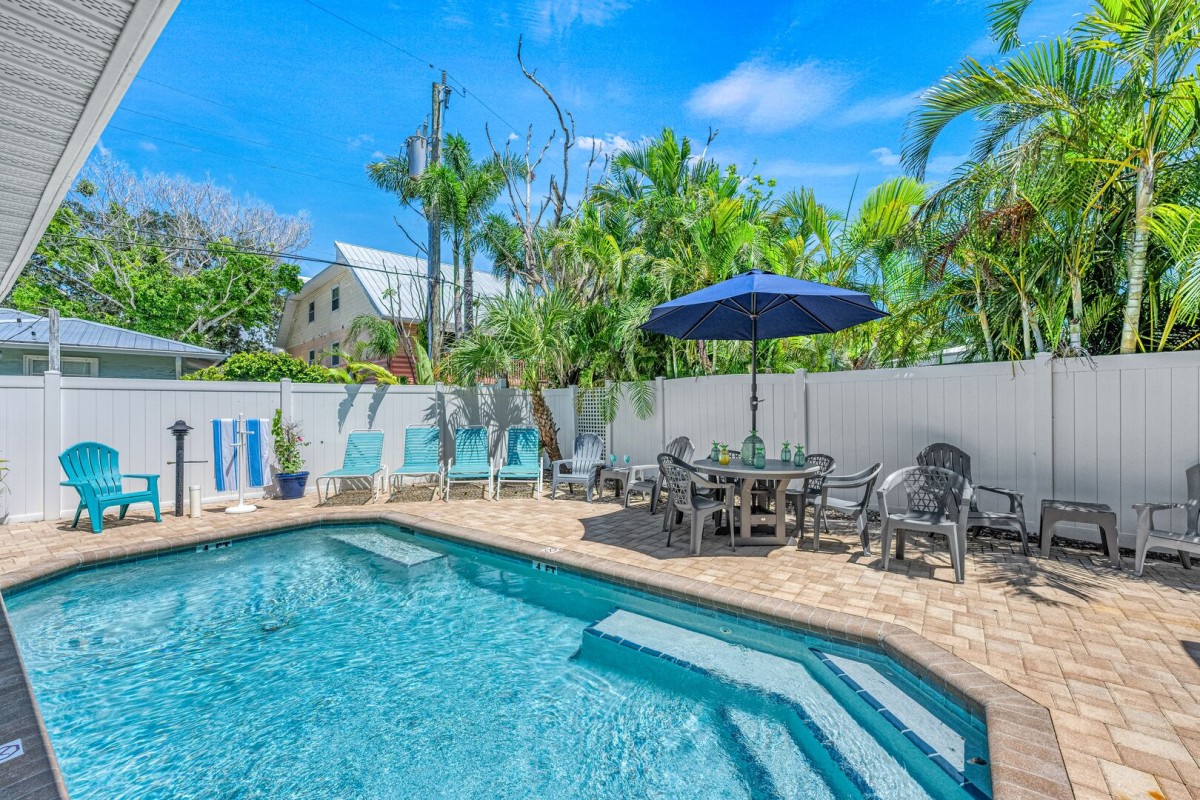 From the comfort of a lounge chair, look out across the sparkling turquoise water, framed by tropical greenery dappled sunlight.