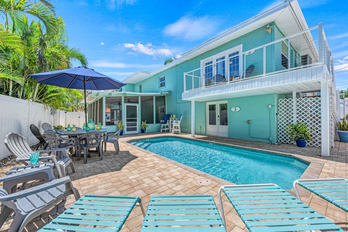 The Hummingbird's full-size heated pool reserved solely for your group. Surrounded by loungers, chairs umbrellas, and lush palms, it's an ideal spot for sun-soaked days.