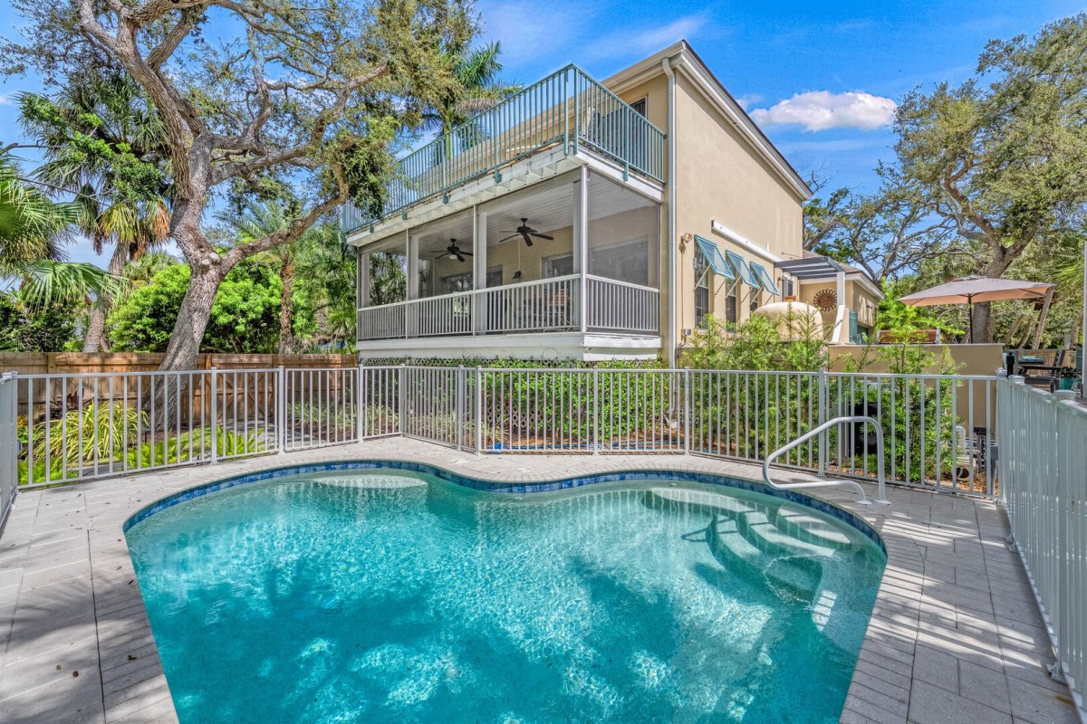Step into your private retreat—this heated pool is the heart of the home, framed by tropical landscape and Florida sunshine.