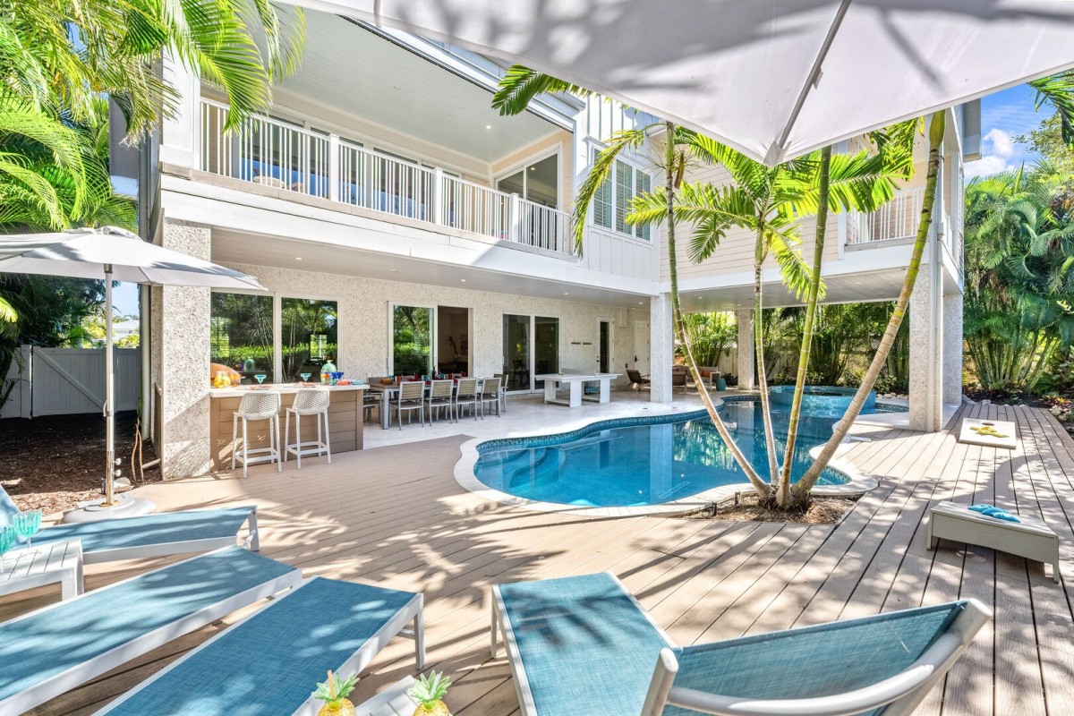 Step into sunlit luxury and feel instant calm beside your private heated pool framed by shimmering canal views.