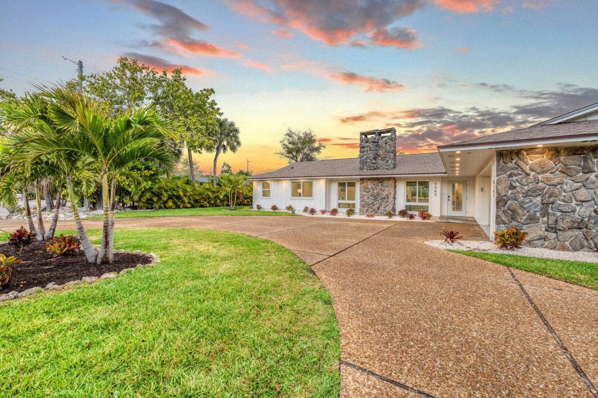 Siesta Sun Oasis welcomes you with a spacious driveway and tropical landscaping.