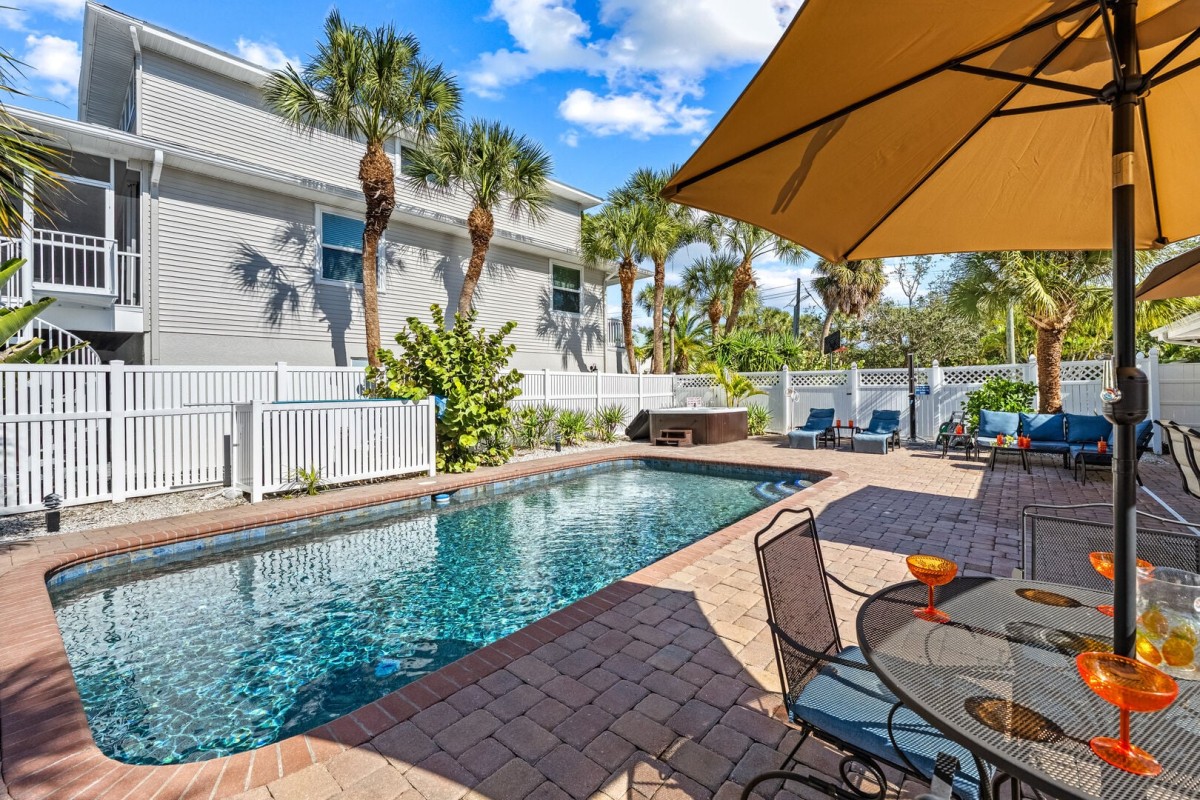 A private backyard oasis featuring a heated pool, hot tub, and plenty of space to relax and entertain.