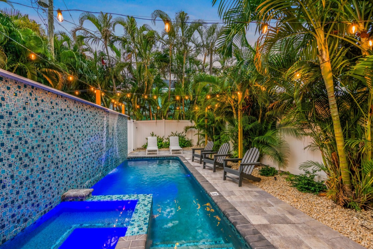 Your own backyard retreat features a heated pool, spa, cascading waterfall, and lush palms for added privacy.