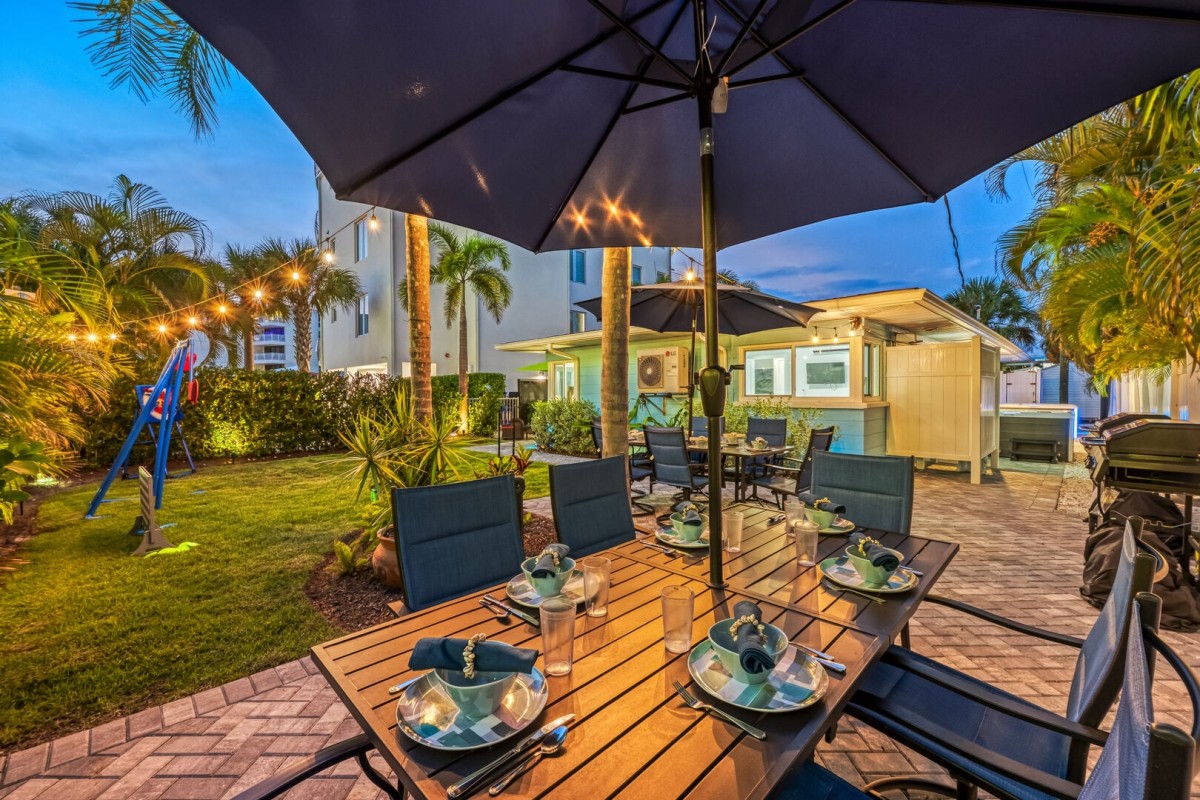 Dinner under the palms feels even better after sunset, with string lights setting the scene.