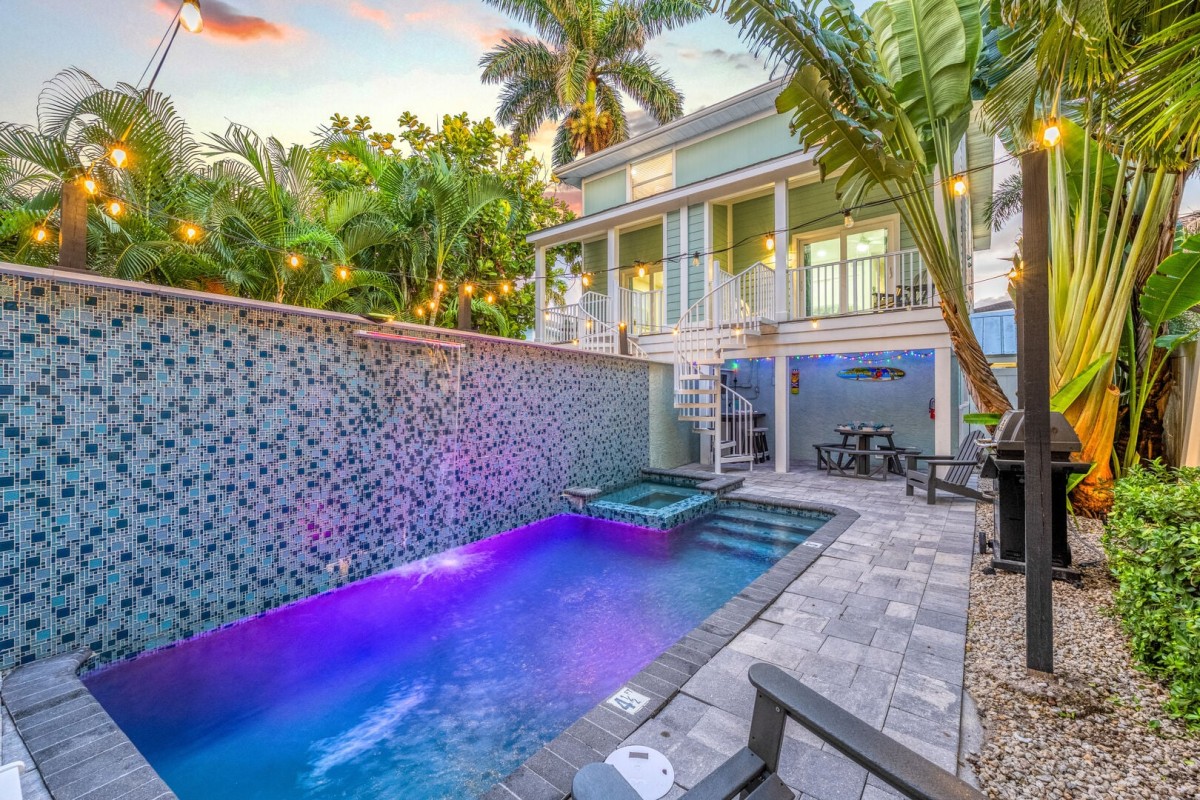 A private pool and spa invite you to cool off between beach adventures, while the spiral staircase leads to additional outdoor living spaces above.