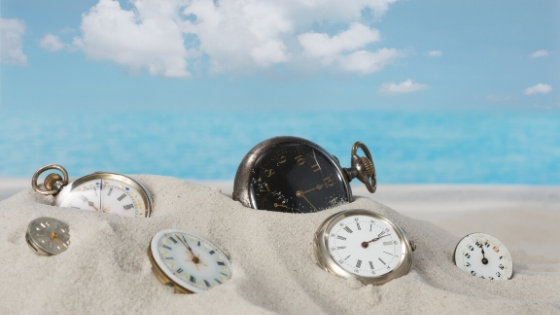pocket watches in sand of beach