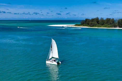 sailboat on the ocean with island in distance