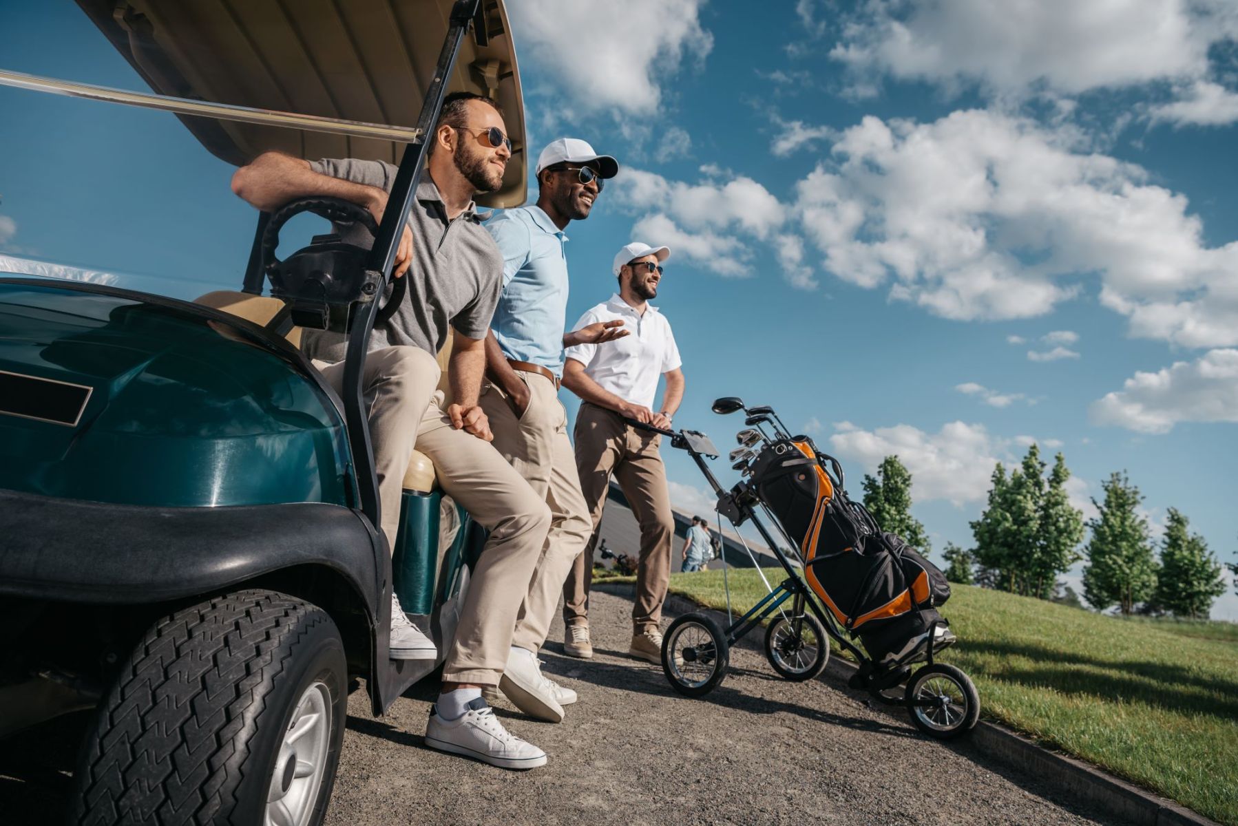 group of men exiting their golf cart on the course