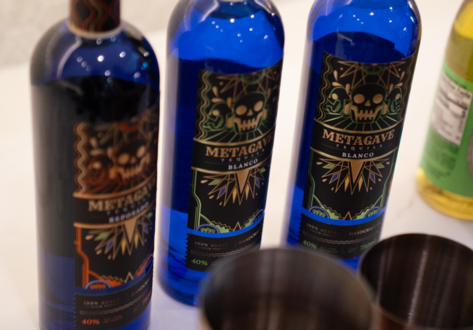 Three decorative blue glass wine bottles featuring custom painted local map artwork.