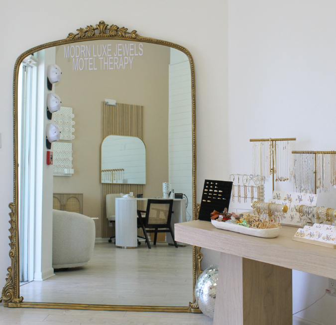 Bright luxury retail boutique interior displaying gold jewelry and fine decor.