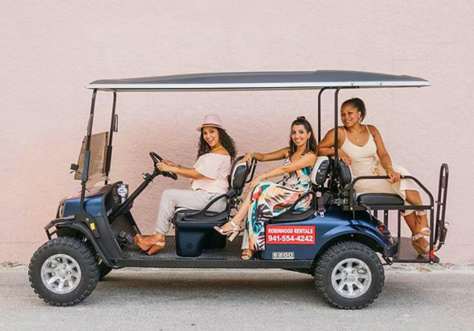 Group of friends smiling while riding together in a street-legal custom rental golf cart.