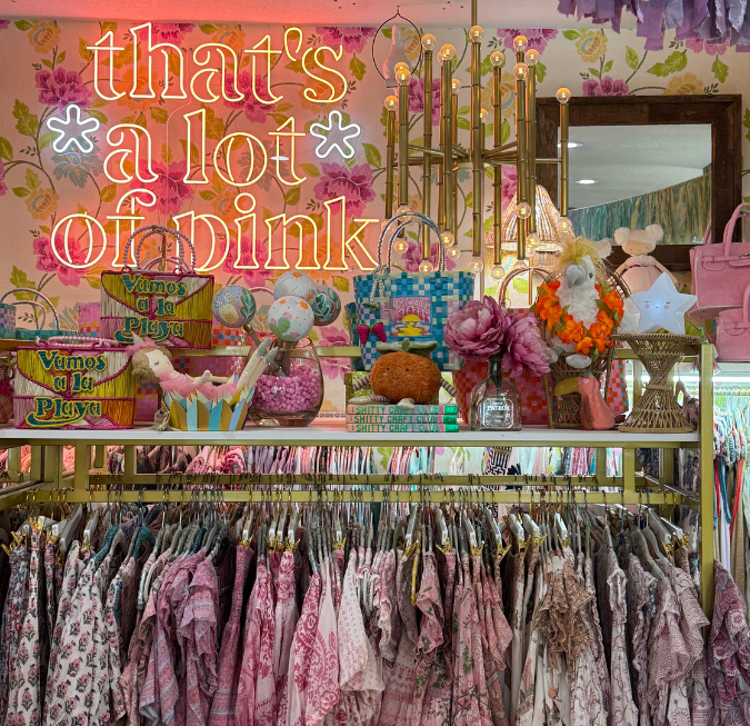 Inside a colorful clothing store showing vibrant patterned apparel hanging on a rack.