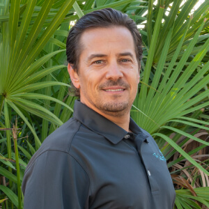 Dan Headshot of a smiling male executive with short hair wearing a dark shirt.